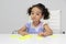 3-year-old Latina girl with brunette and curly hair plays with a game of letters and numbers for learning within the autism