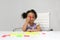3-year-old Latina girl with brunette and curly hair plays with a game of letters and numbers for learning within the autism