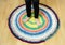 3 year old young child standing on round colorful crochet rug from repurposed T-shirts.