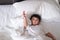 3 years old little sick or illness Asian boy at home on the bed, sad kid laying resting on white bed with pillow and blanket, top