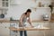 30s woman leaning over table, rolling out dough.