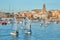 30th International Vila de PalamÃ³s Optimist Trophy, 14th Nations Cup. Sailboats sailing to the harbor small town Palamos in