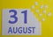 31 august calendar date on a white puzzle with separate details. Puzzle on a yellow background with a blue inscription