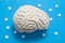 3D anatomical model of brain is on blue background surrounded by white pills as ornament polka dots. Medical concept by pharmacolo