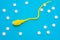 3D anatomical model of sperm cell or spermatozoon is on blue background surrounded by white pills as ornament polka dots. Photo co