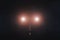 3D car headlights on a foggy road at night