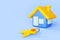 3d cartoon house building and door keys on blue background. Concept of buying or selling property, real estate