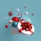 3d Christmas ornaments. Glass balls falling out of open round box, white wrapped gift with red bow. Winter holiday package.