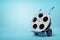3d close-up rendering of film reel on blue hand truck on light-blue background.