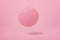 3d close-up rendering of light pink basketball bouncing on light pink background.