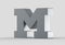 3D extruded uppercase letter M isolated on soft gray background.