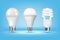 3D glowing CFL and LED light bulbs on blue background, realistic style. Idea, creativity and innovation concept