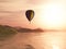 3D hot air balloon against sunset landscape