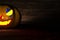 3D illustration, 3D rendering, The head of a scary demon pumpkin on the floor and wooden wall
