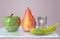 3d illustration of apple banana in glass and pear creative still life on glass table in pink room with day light imitation