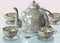 3d illustration of china checkered teakettle and cups on glass table in pink room