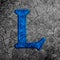 3d illustration cracked blue stone wall letter L on black grunge cement surface