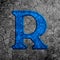 3d illustration cracked blue stone wall letter R on black grunge cement surface