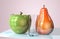 3d illustration of green apple pear and glass creative still life on glass table in pink room with day light imitation