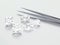 3D illustration group of white different diamonds stones with tweezers