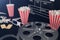 3d illustration of popcorn, drinks, clapperboard, filmstrip and two tickets. Cinema concept on dark background