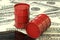 3d illustration: Red barrels of oil lie on the background of dollar money. Petroleum business, black gold, gasoline production