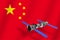 3D model of China`s Tiangong-1 space station orbiting the planet Earth with the flag of China in the background