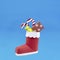 3d paper Santa boot with gifts on blue background