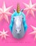 3D polygon paper unicorn head with golden horn on pink background.