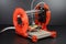 3d printing robot, with extruder head and nozzle printing on roll of filament