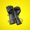 3d render, black human hands wrapped with barbwire, isolated on yellow background. Fists of anger. Fight for human rights