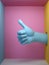 3d render, blue female mannequin hand like gesture isolated on pink background, hole in the wall, thumb up, artificial body parts