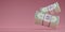 3D render Bundle cash is falling on pink background .Floating US Dollar bills bundles stack icon. copy space. Minimal style money