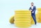 3d render businessman character with golden coin on blue background. Cartoon character with coin.