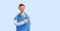 3d render, caucasian young man, nurse cartoon character wears blue shirt, looks at camera, shows right direction with finger.