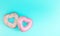 3d render of couple of heart-shaped donuts on blue background. Valentine`s concept.