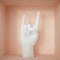 3d render, female mannequin hand, rock gesture isolated on peachy background, hole in the floor, fingers up, white artificial body