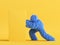 3d render, hairy Yeti cartoon character pushes the big heavy box, furry blue monster. Funny clip art isolated on yellow background