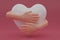 3D render hands hugging a white heart with love. Hand embracing white heart isolated on pink background. love yourself. used for