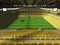 3D render of a large capacity soccer-football Stadium with an open roof and yellow seats