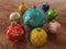 3D render of multicolour holiday decoration baubles on wooden surface
