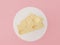 3d render piece of Cheese for making food. Cheese slice on white circle and pastel pink background. Healthy food idea concept