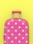 3d render of pink suitcase over yellow background