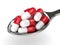 3D render of spoon with l-carnitine pills over white