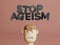 3d render of text Stop ageism and cartoon man head. Social problem of inequality of ages. Job refusal for elderly people