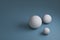 3d render, three white spheres with different sizes on blue background