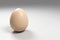 3d rendered brown egg on grey background for wallpapers, greeting cards, posters, ads.