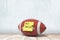 3d rendering of american football ball with yellow `Match tomorrow` sign on white wooden floor and white wall background