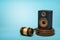 3d rendering of audio loudspeaker on round wooden block and brown wooden gavel on blue background