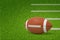 3d rendering of a ball for American football lying on green pitch grass with white lines on the right and with copy